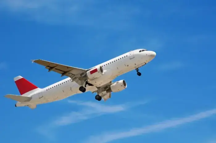 A white airplane flying in the sky.