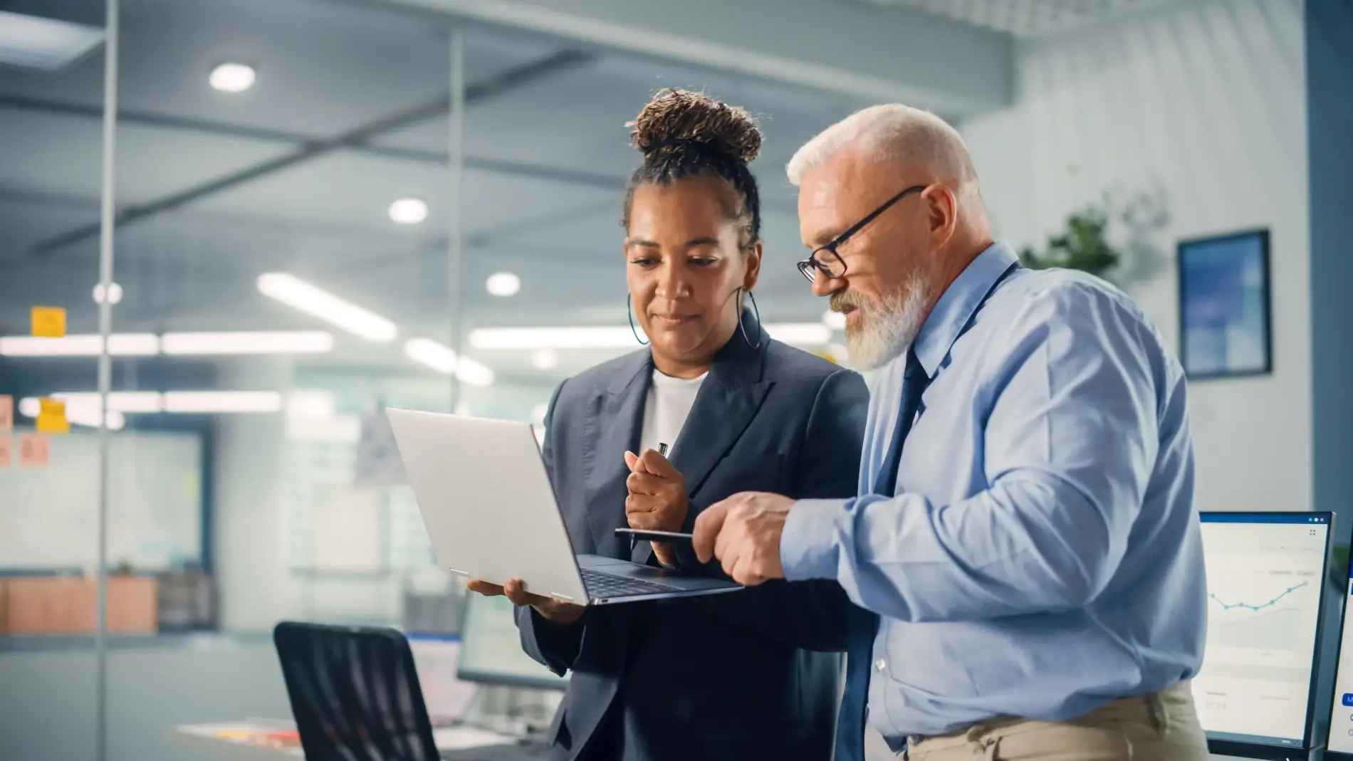 Two business people looking at a laptop in an office.