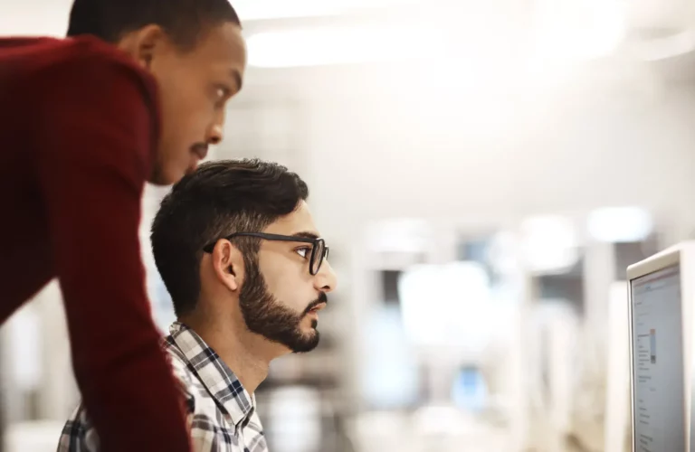 Two men looking at a computer screen.