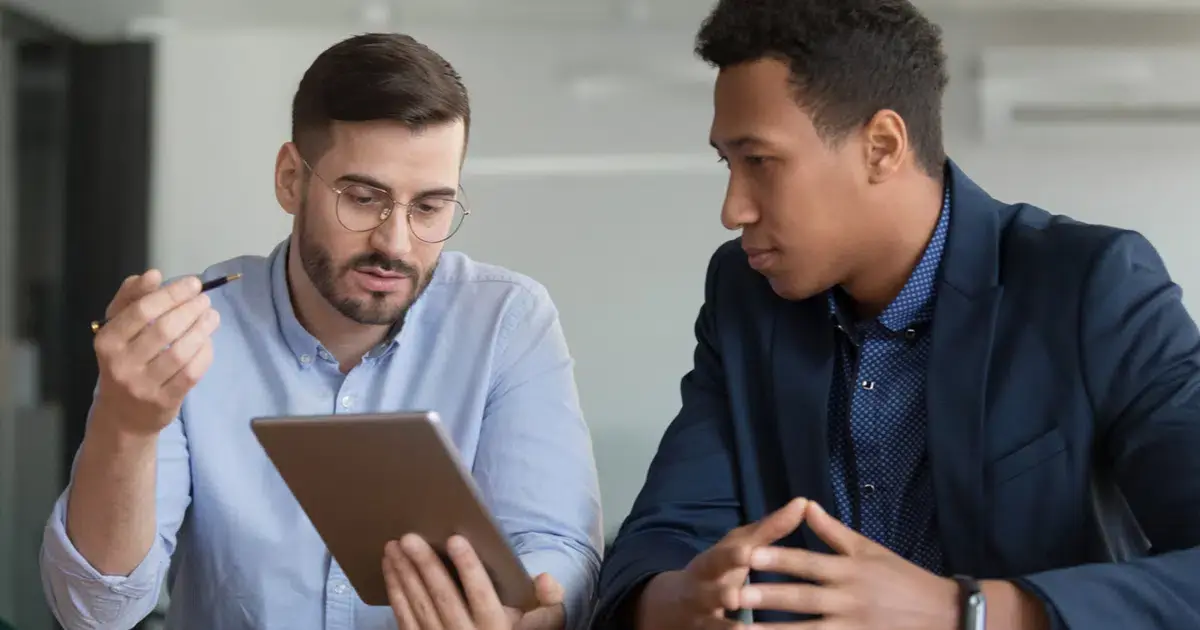 Two businessmen looking at a tablet computer.