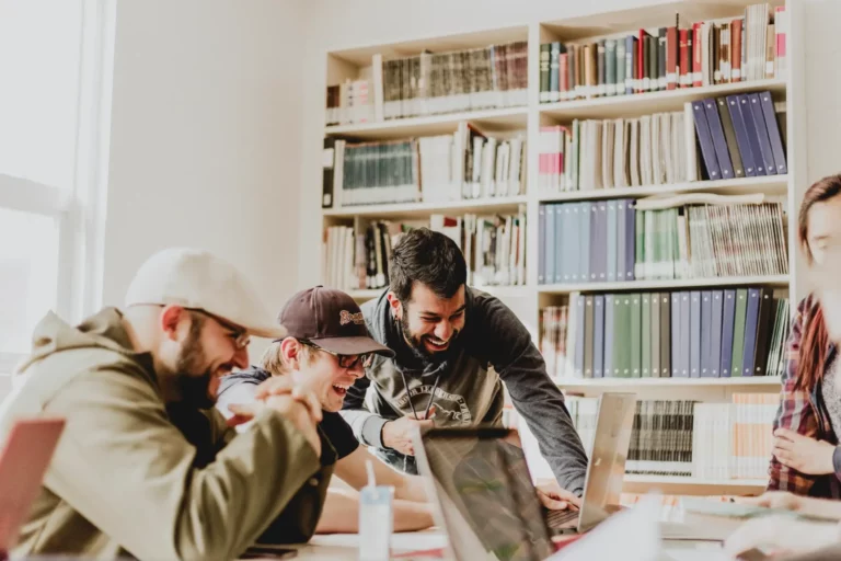 A group of people working on laptops in a library.