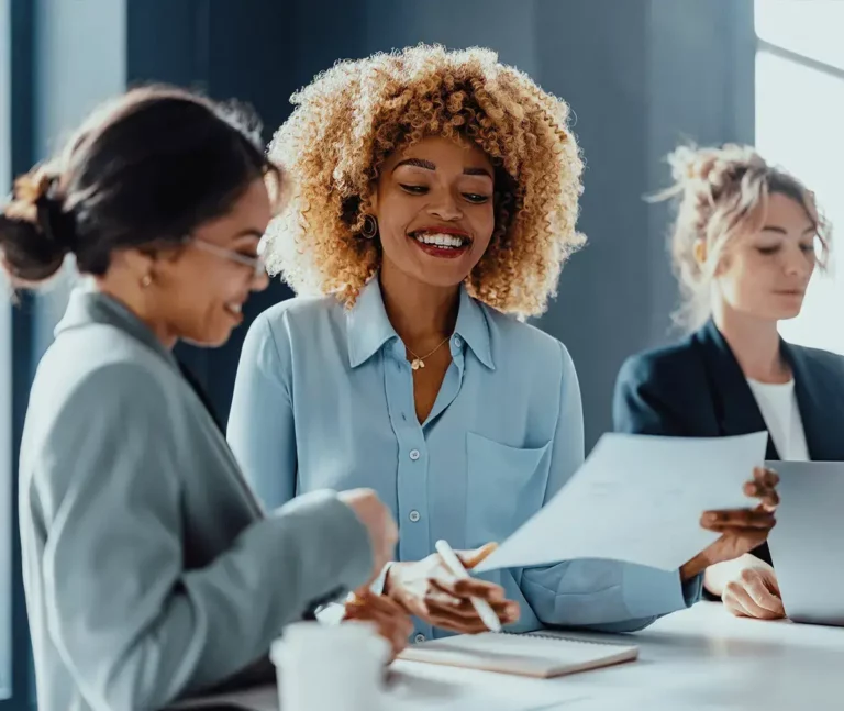 A group of business women sitting around a table.