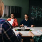 A group of people sitting around a table in a meeting room.