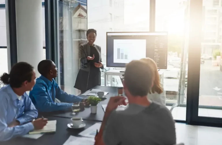 A group of people sitting around a table in a conference room.