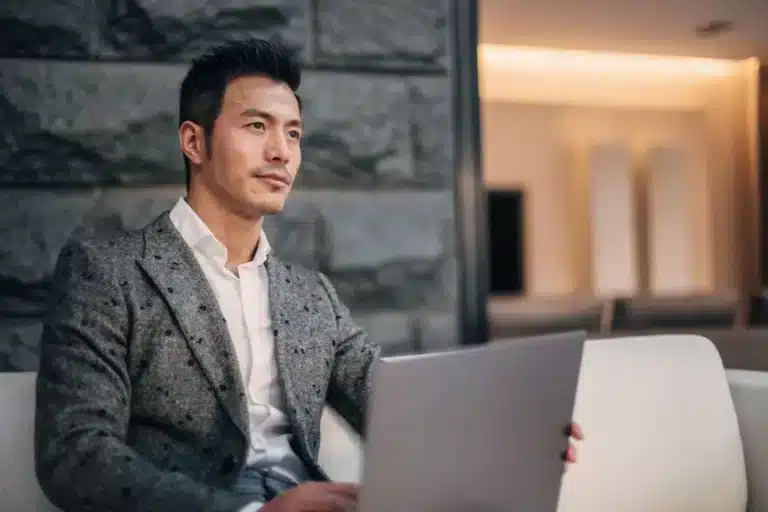 A man sitting on a couch with a laptop.