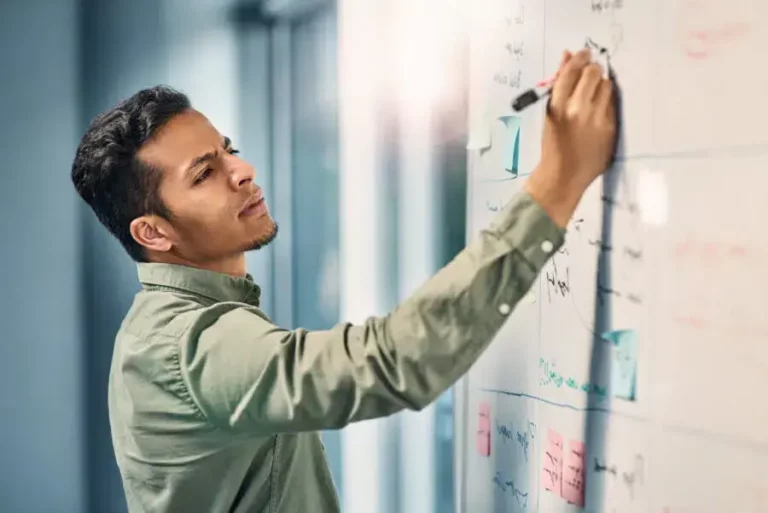 A man writing on a whiteboard.