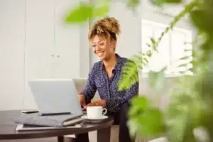 A woman sitting on a couch and using a laptop.