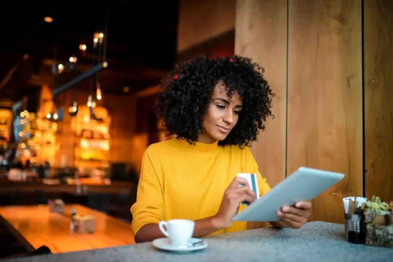 A young woman using a tablet at a restaurant.