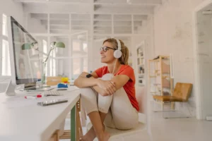 A woman sitting on a chair in front of a computer.