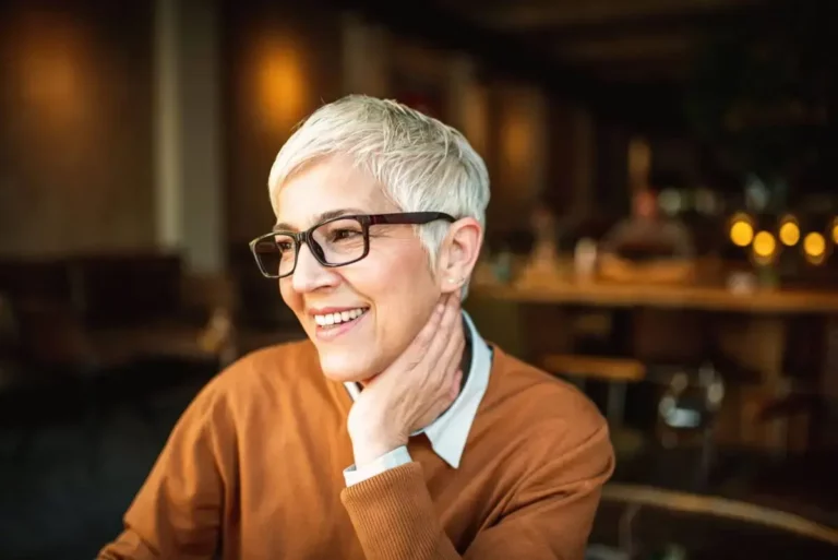 A woman in glasses sitting at a table.